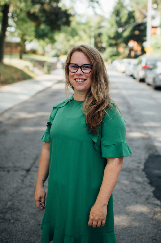 Natasha Brown standing outside in the middle of a quiet street on a summer day