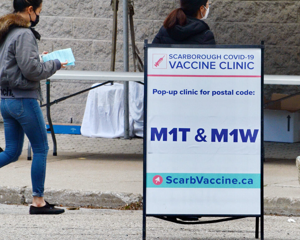 People wait in line for a Covid-19 vaccine at the pop-up vaccine clinic at L'Amoreaux Collegiate