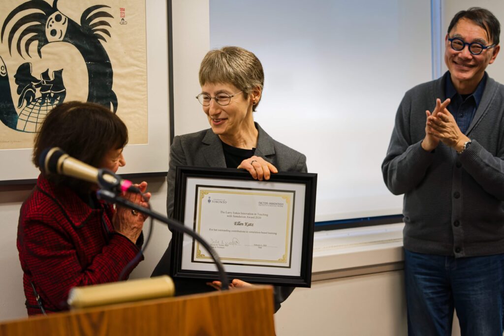 Associate Professor Ellen Katz, receiving the inaugural Larry Enkin Innovation in Teaching with Simulation Award in February 2020, presented by Professor Marion Bogo, with A. Ka Tat Tsang looking on.