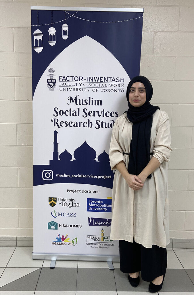 Mishal Dar, project coordinator for the SSHRC-funded research project "Exploring the Social Service Needs of Muslims in Ontario" and co-founder of the Muslim Human Service Alliance, stands by a banner advertising the Muslim Social Services Research Study at the Factor-Inwentash Faculty of Social Work
