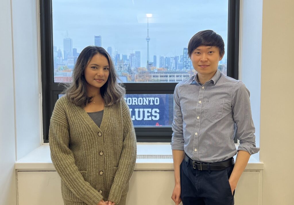 Samar Hossain and Matthew Cho, in FIFSW's Dean's Boardroom with Toronto's skyline visible through the window