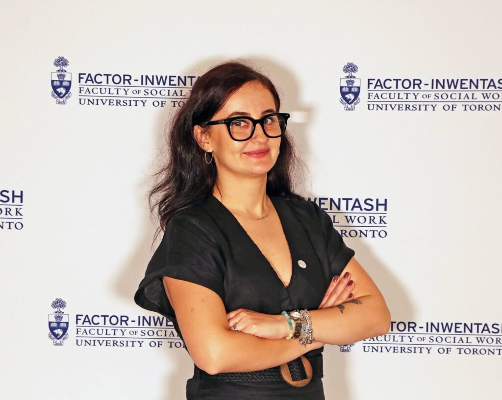 Ayse Kumsal Tekirdag-Kosar stands in front of FIFSW logo-covered "step and repeat" 
