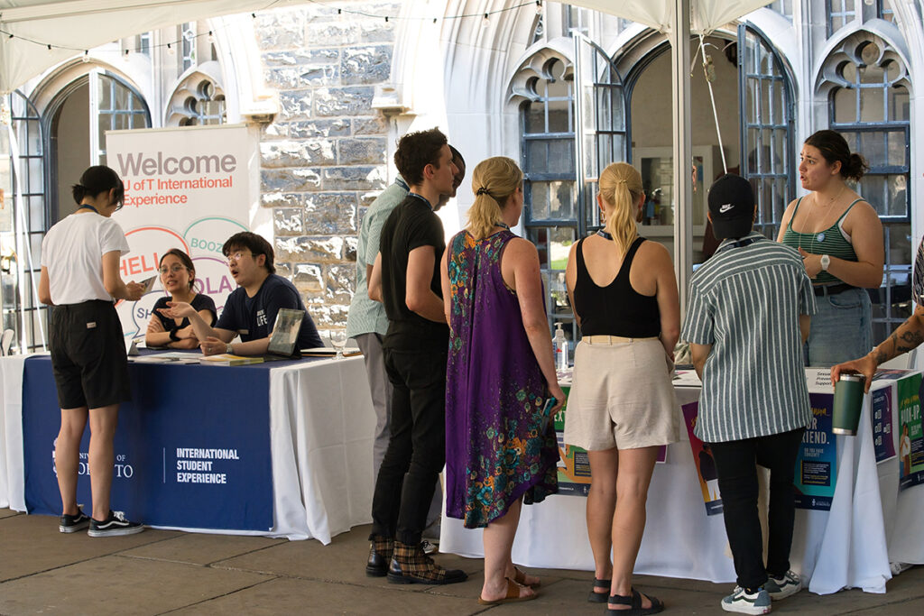 students speak to student services staff manning tables in the Hart House quad