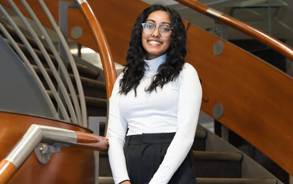 Shuruthii Thiyagasoruban poses for a photo on the staircase in FIFSW's front lobby