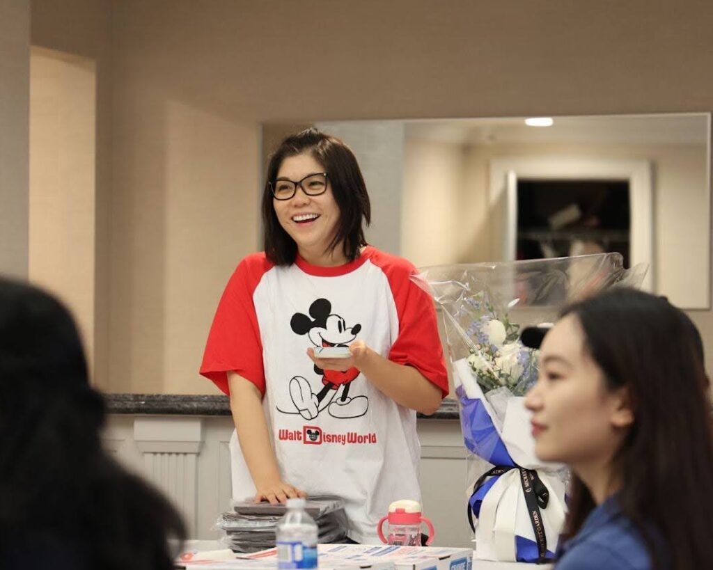 A smiling Jia Xue speaks to AIJ Lab members at the 4th anniversary celebration.