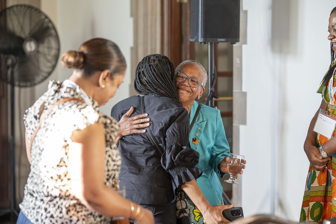 Dr. Bernard, smiling, hugs an audience member during the reception