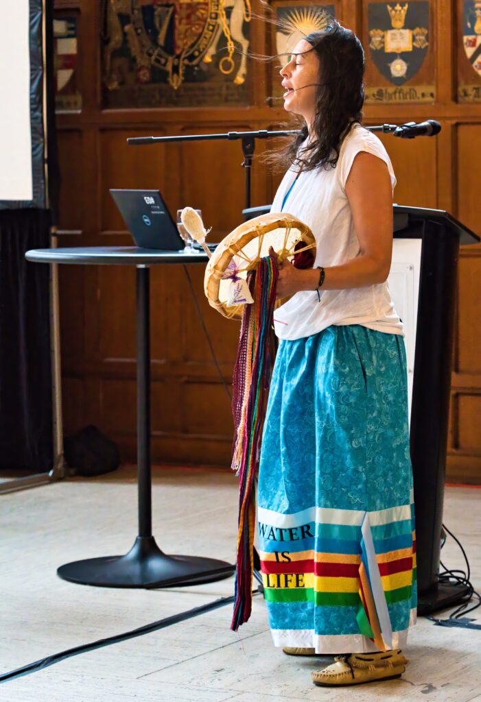 Assistant Professor Ashley Quinn drumming at the introduction to Social Work conference.