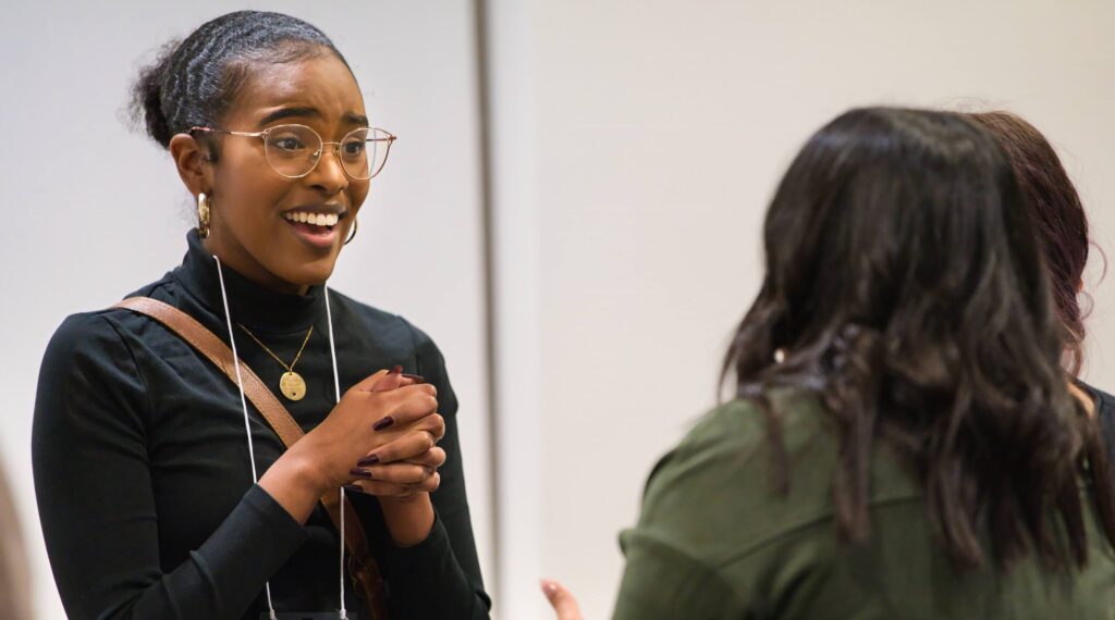 A student in conversation with others at an alumni mentorship event