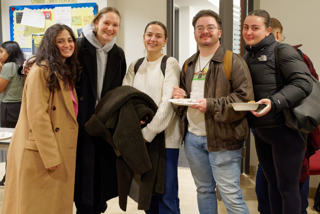 5 students, wearing or holding winter coats at the winter solstice gathering